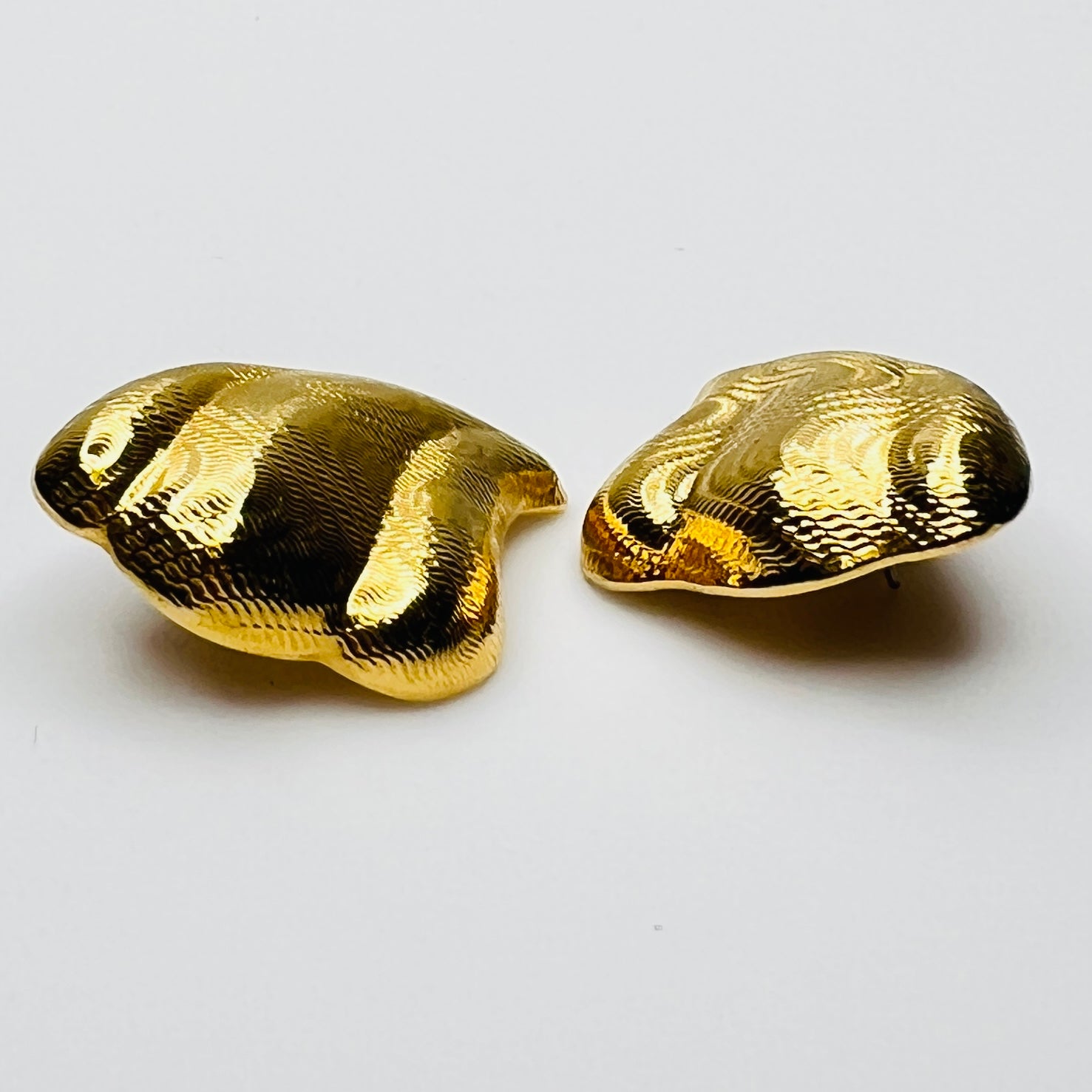 Side view of vintage 1980s gold tone pierced statement earrings