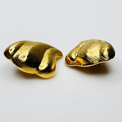 Side view of vintage 1980s gold tone pierced statement earrings