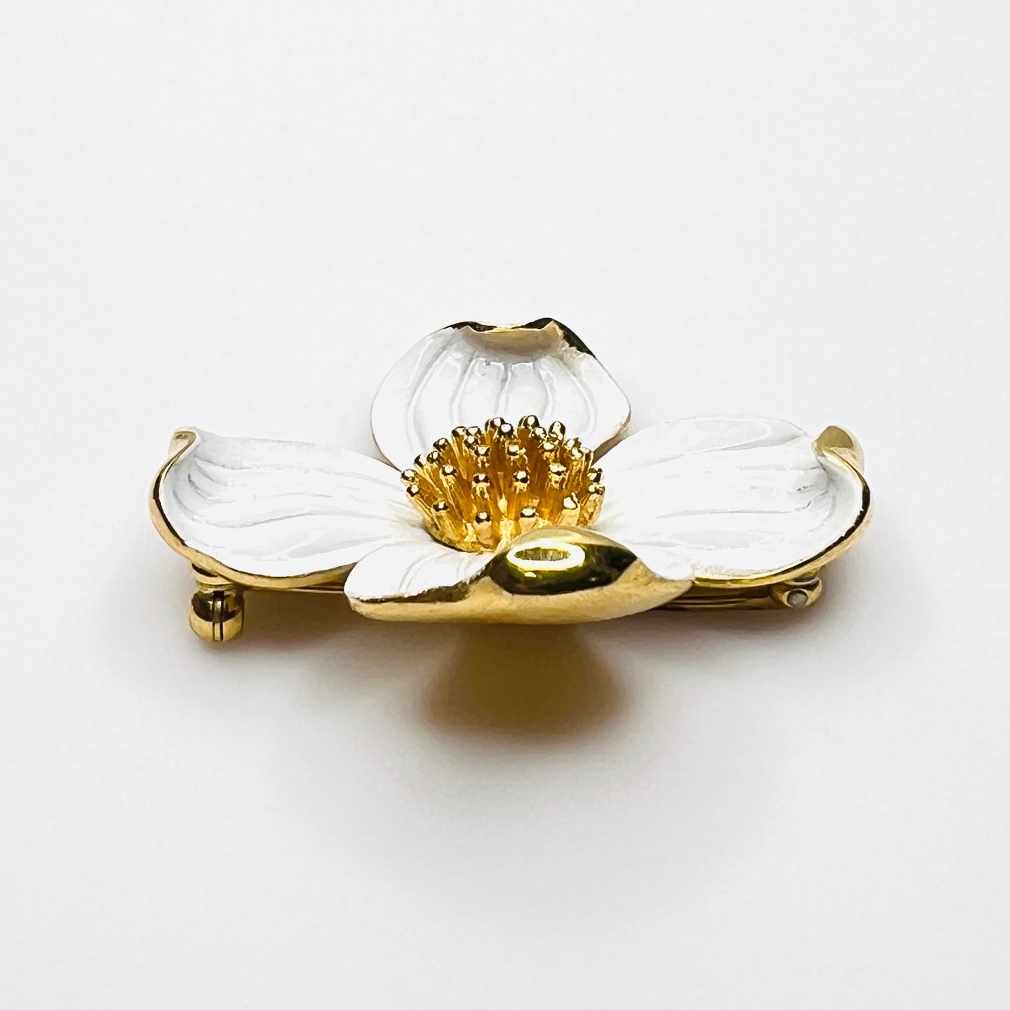 Side profile of vintage Trifari white enamel dogwood brooch showing dimensional petals.