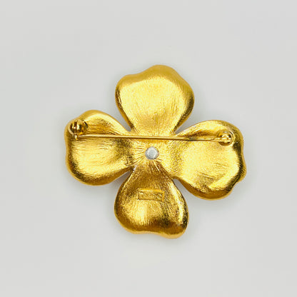 Reverse of signed Crown Trifari white enamel flower brooch with secure pin clasp.