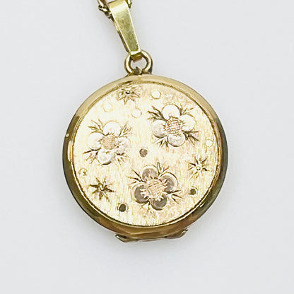 Close-up of engraved floral gold plated sterling silver round locket pendant