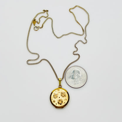 Close-up of engraved floral gold plated sterling silver round locket pendant
