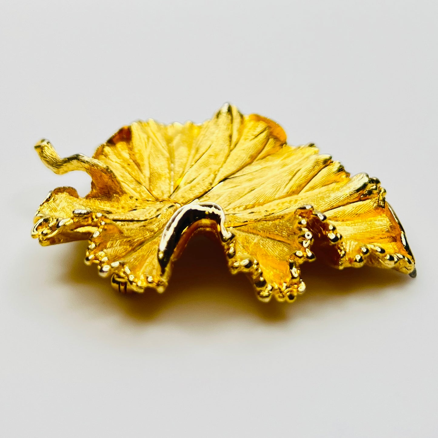 Side profile of textured gold leaf brooch