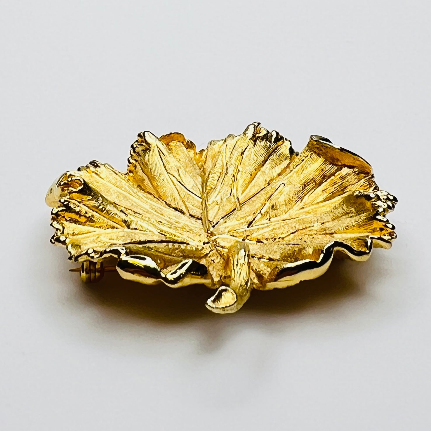 Side profile of textured gold leaf brooch