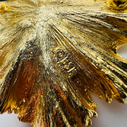 Close-up of BSK signature on gold brooch