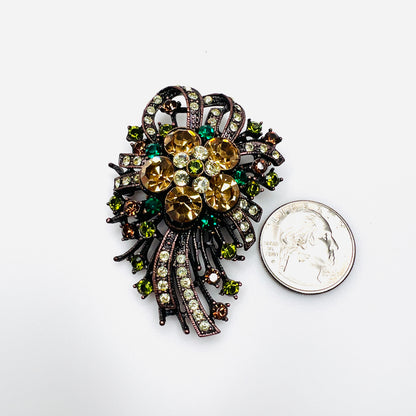 Large Joan Rivers rhinestone statement brooch beside quarter showing scale