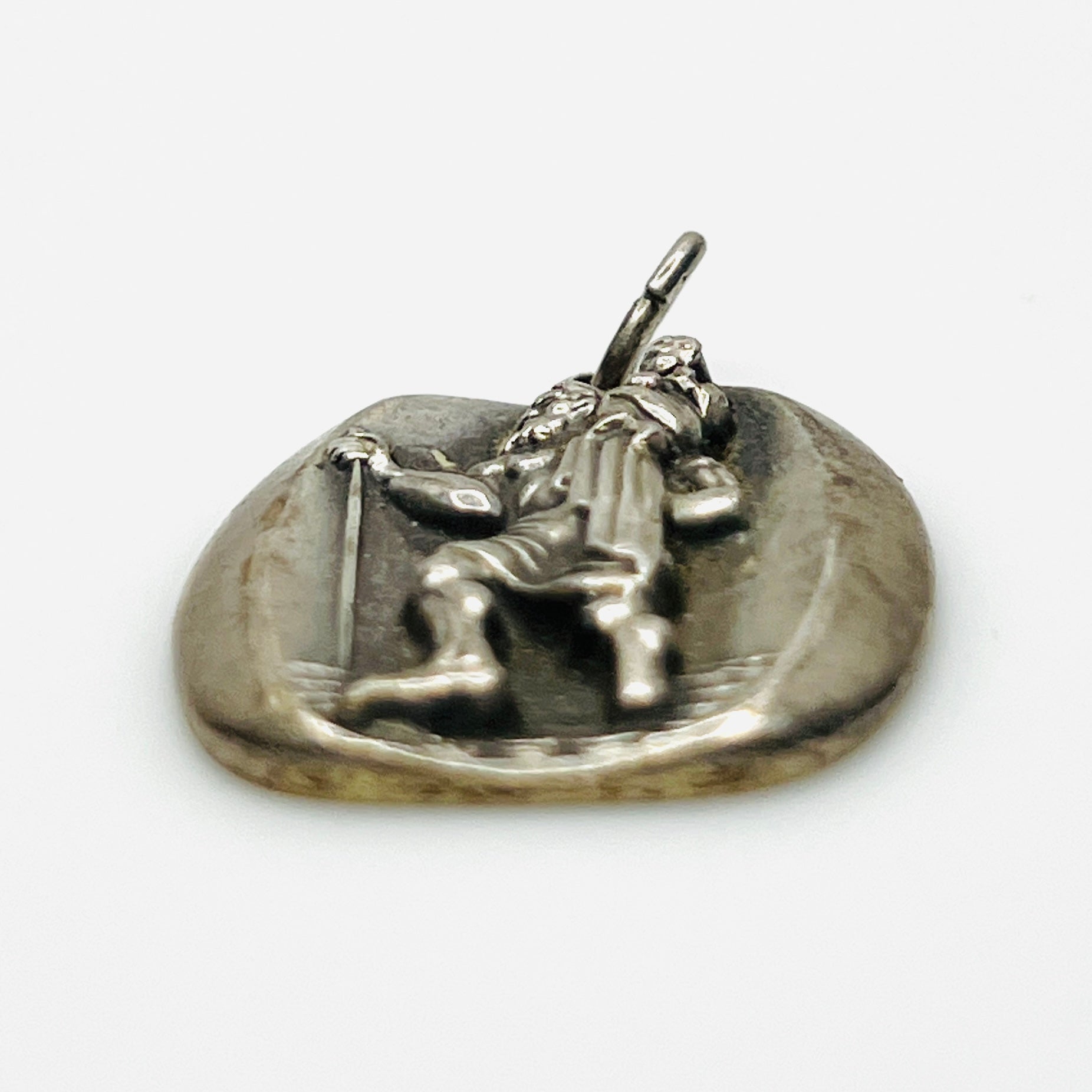 Side profile of vintage sterling silver St. Christopher medal pendant showing thickness.