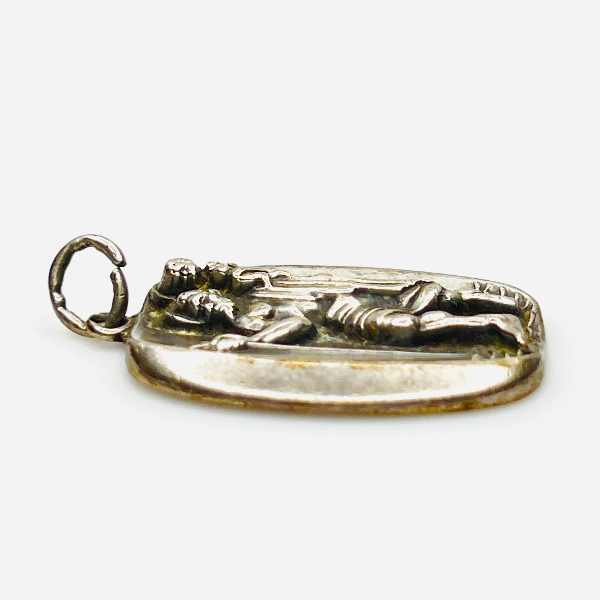 Side profile of vintage sterling silver St. Christopher medal pendant showing thickness.