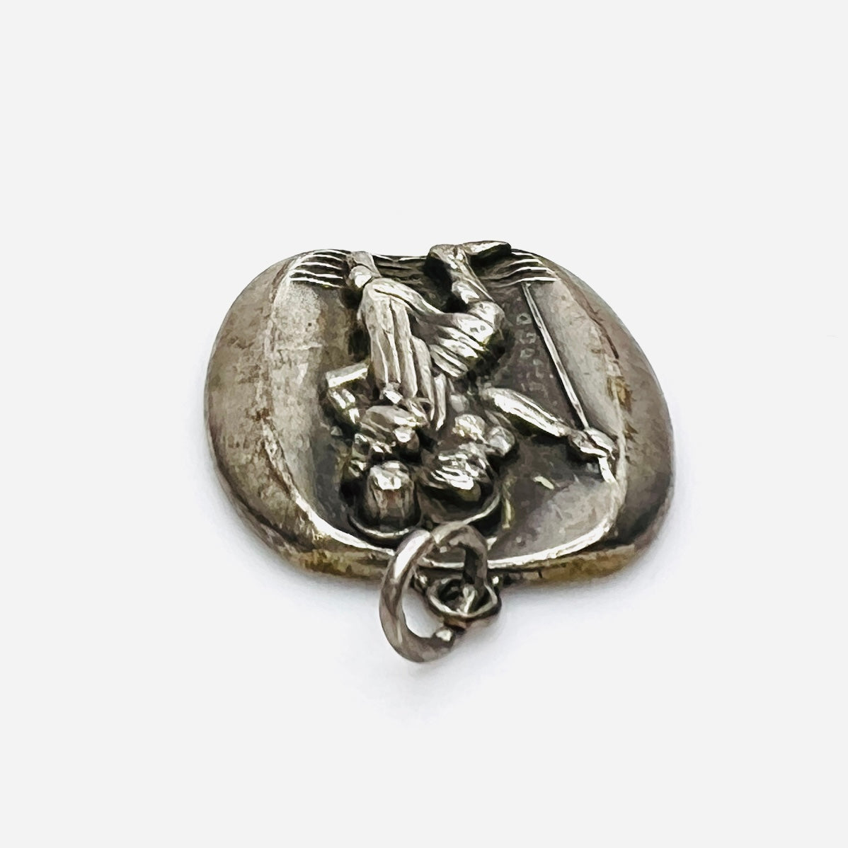 Side profile of vintage sterling silver St. Christopher medal pendant showing thickness.