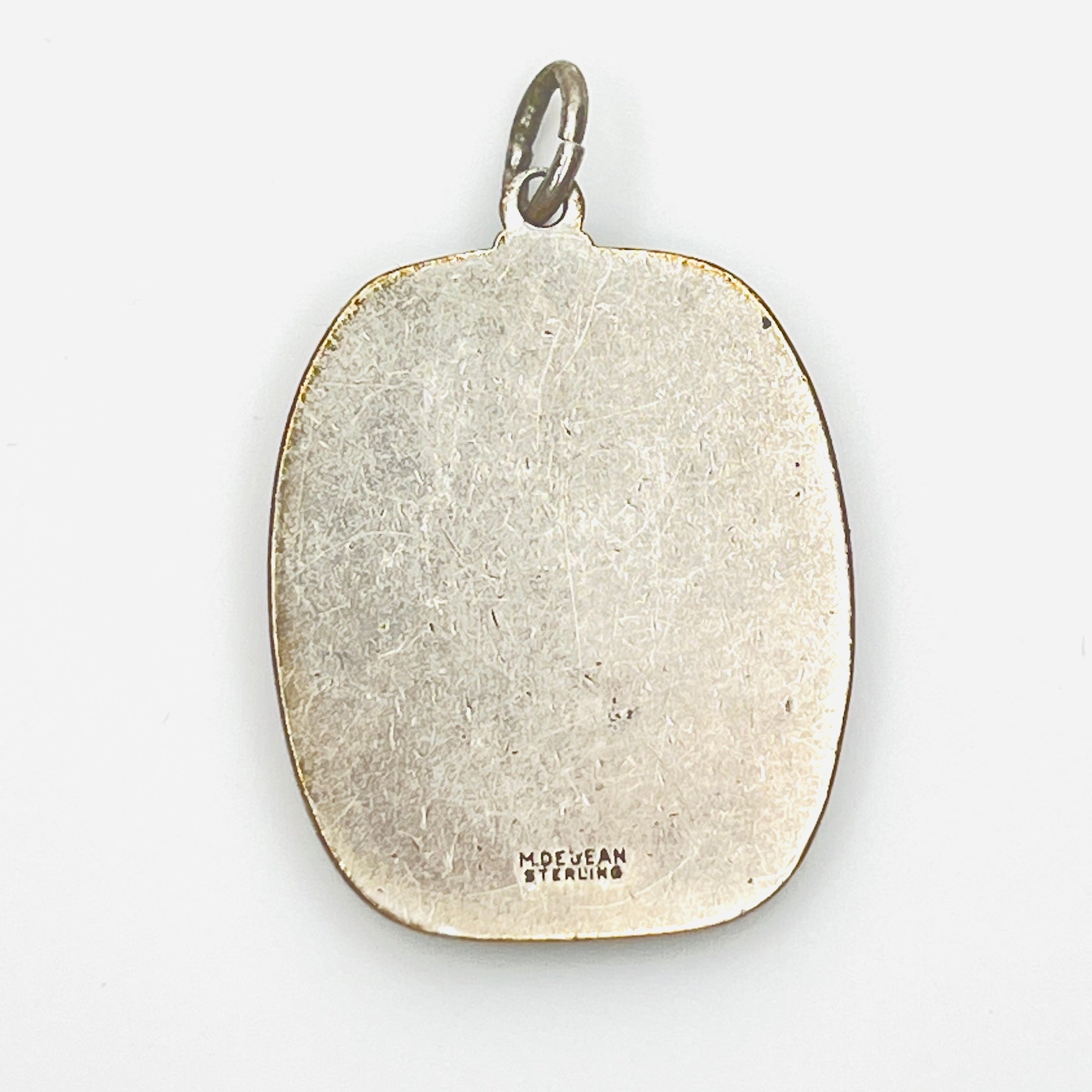 Reverse of signed M. De Jean Sterling St. Christopher pendant with maker's mark.