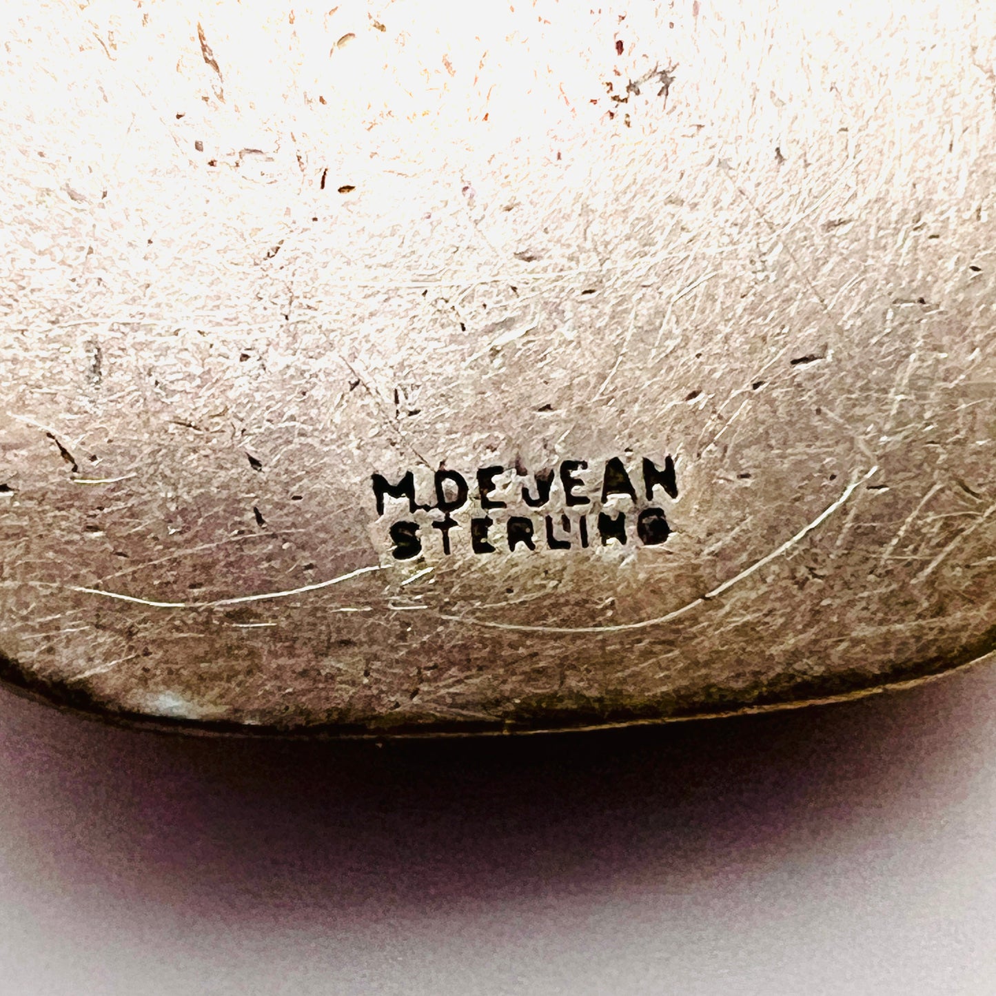 Close up of Reverse of signed M. De Jean Sterling St. Christopher pendant with maker's mark.
