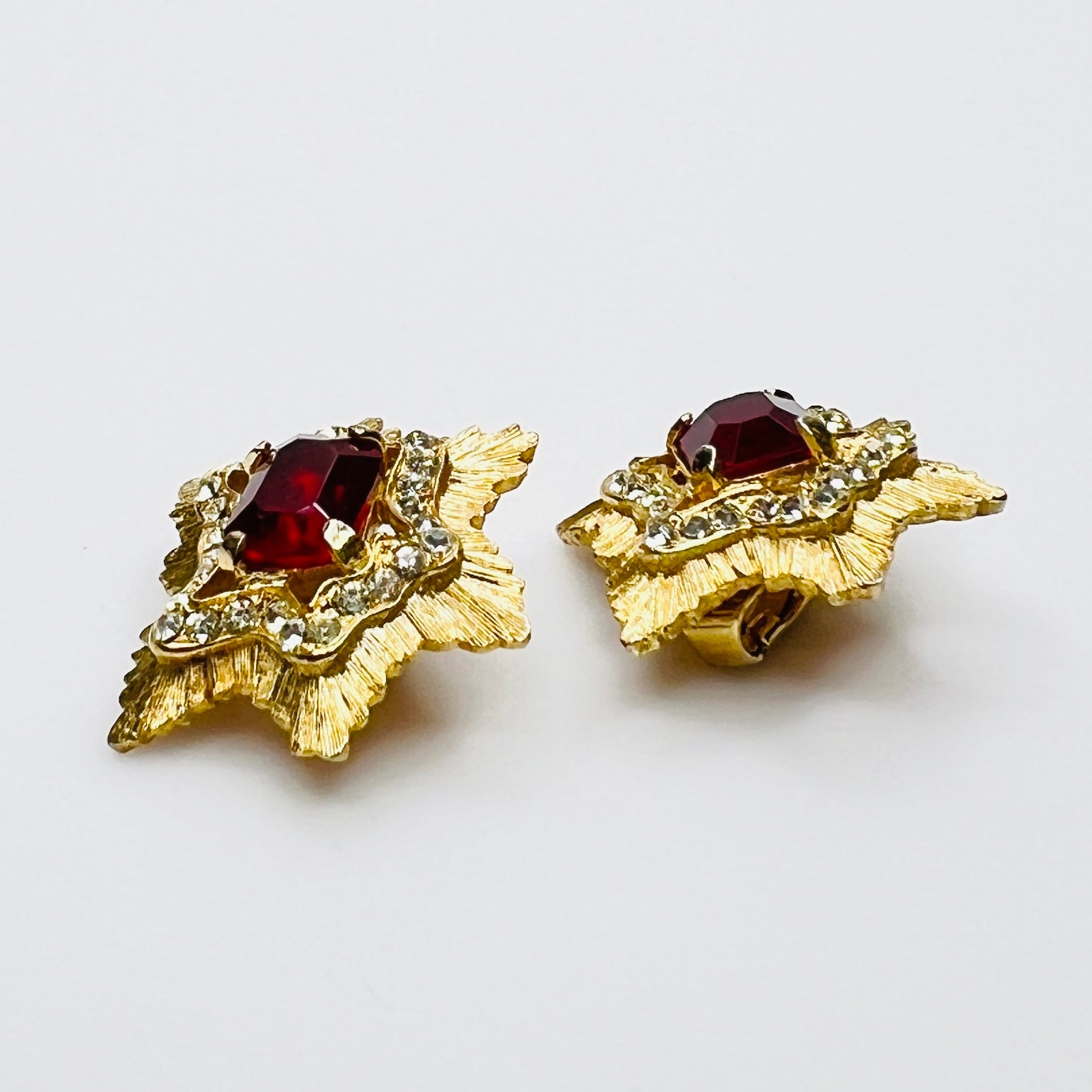 Side view of vintage gold-tone ruby rhinestone clip-on earrings