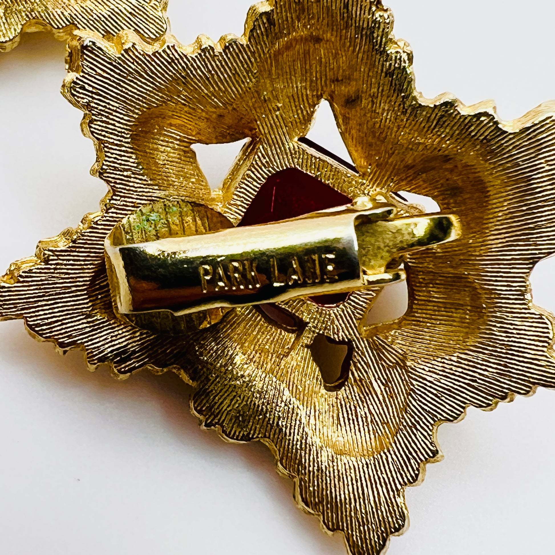 Close-up of signed Park Lane ruby red rhinestone clip-on earring