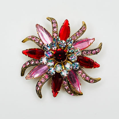 Vintage Selini by Selro flower brooch with ruby-red and pink navette rhinestones, iris crystal accents, and gold-tone petals.