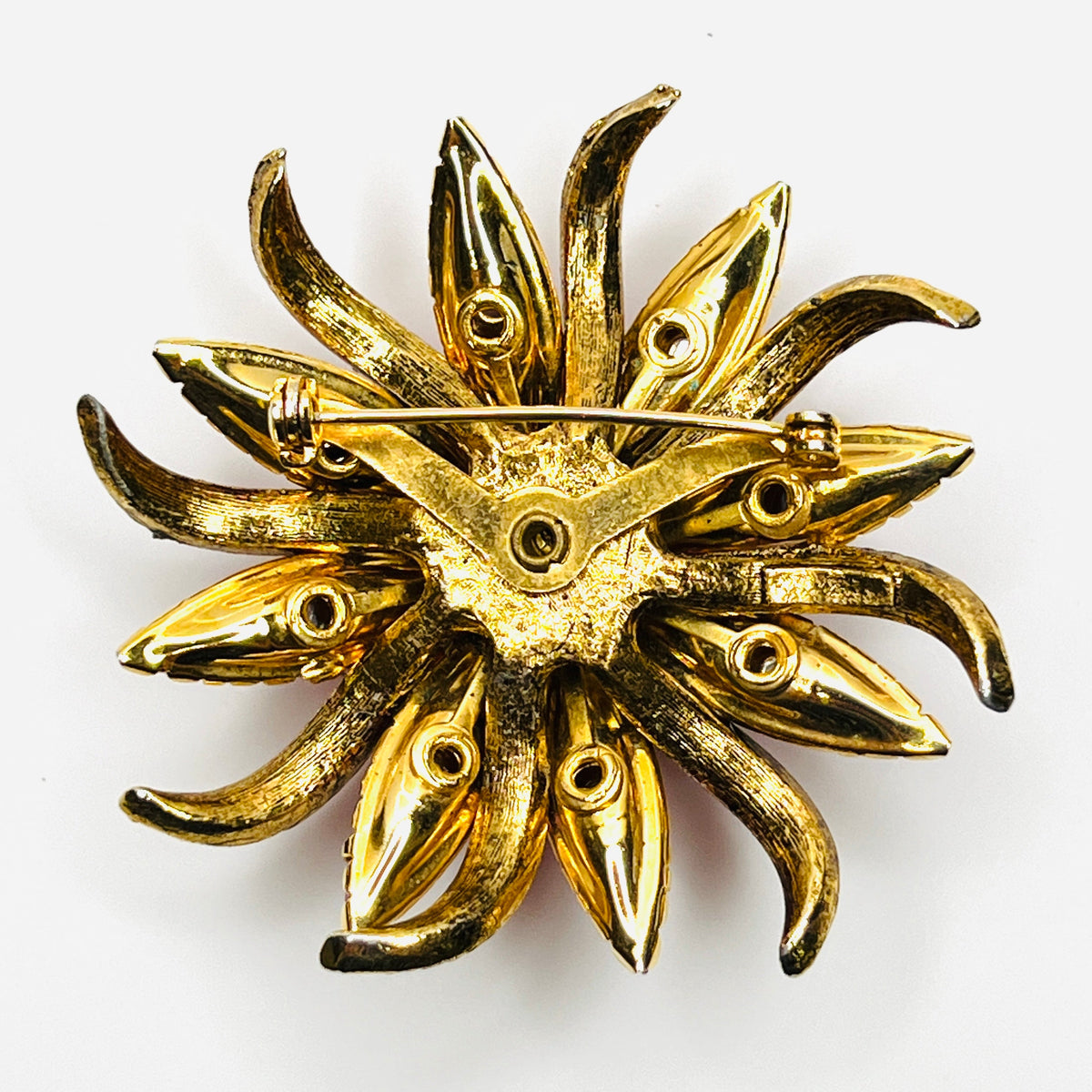 Reverse of vintage Selini by Selro flower brooch showing gold-tone construction, open-back settings, and rollover clasp.