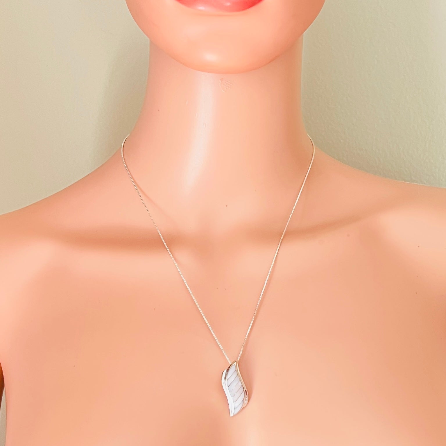 Mother of pearl pendant necklace worn on mannequin silver chain