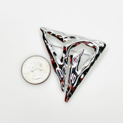 Signed Torino Modernist silver-tone brooch beside a U.S. quarter for size reference.