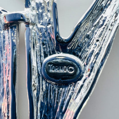 Close-up of Torino signature and copyright mark on vintage abstract brooch.