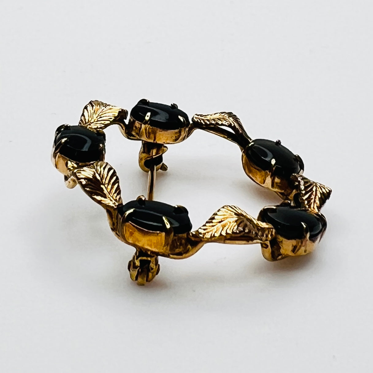 Side view vintage WRE brooch prong set black cabochons gold leaves