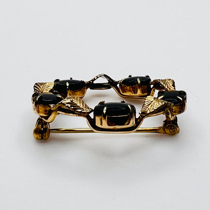 Side view vintage WRE brooch prong set black cabochons gold leaves