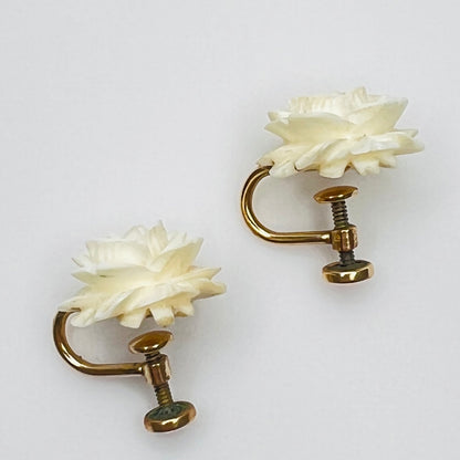 Close-up of floral rose earrings with detailed carved petals