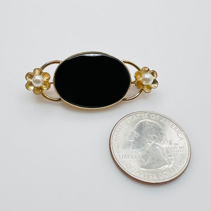 WRE onyx brooch with pearl flowers next to coin