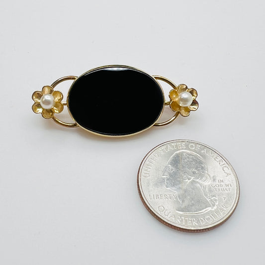 WRE onyx brooch with pearl flowers next to coin