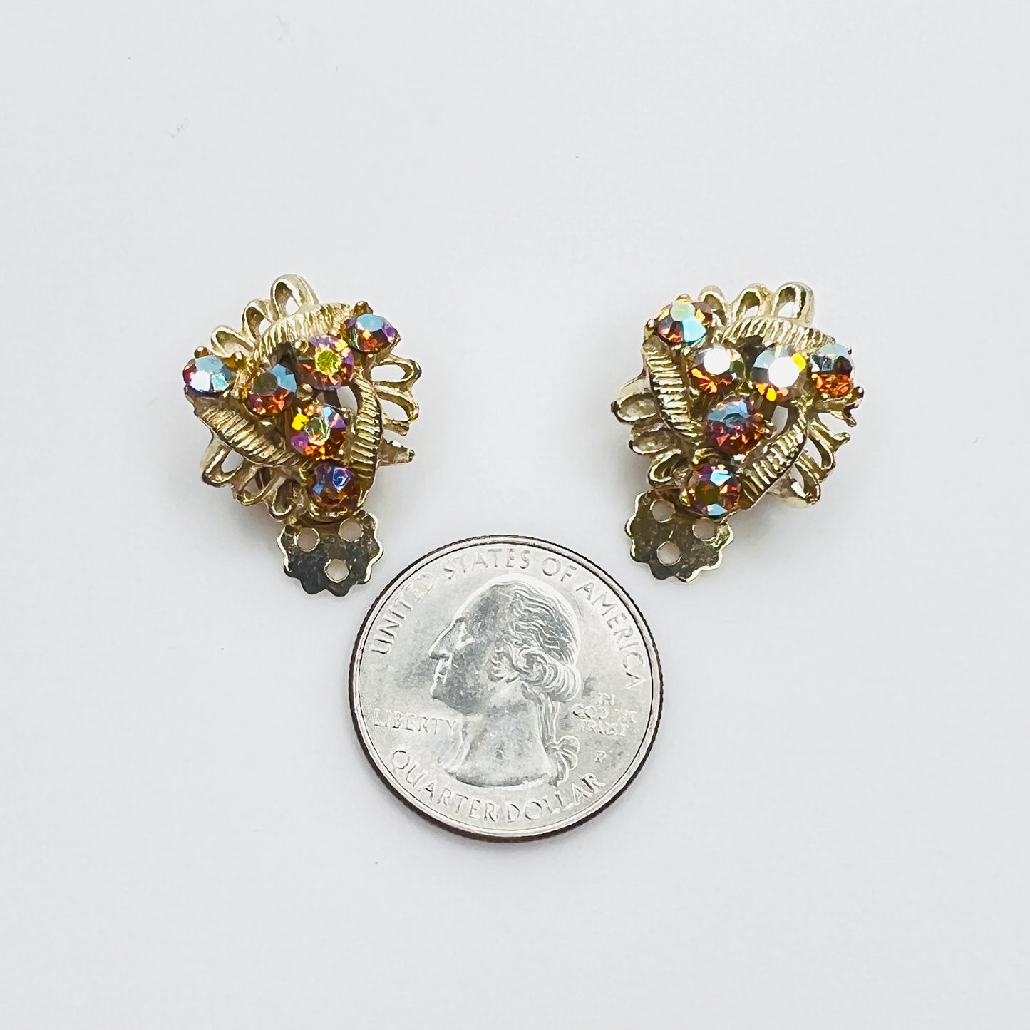 Amber AB rhinestone clip-on earrings with quarter for size comparison.