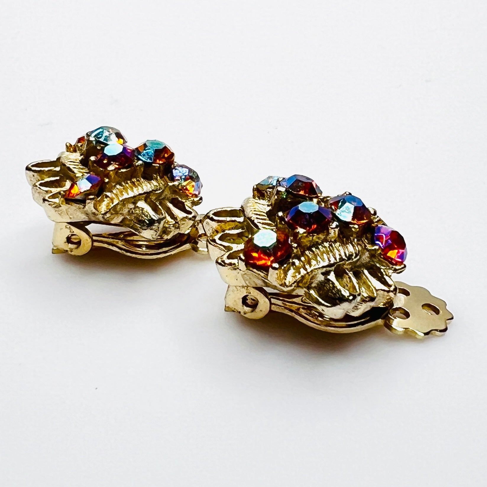 Side profile of vintage gold-tone amber rhinestone clip-on earrings.