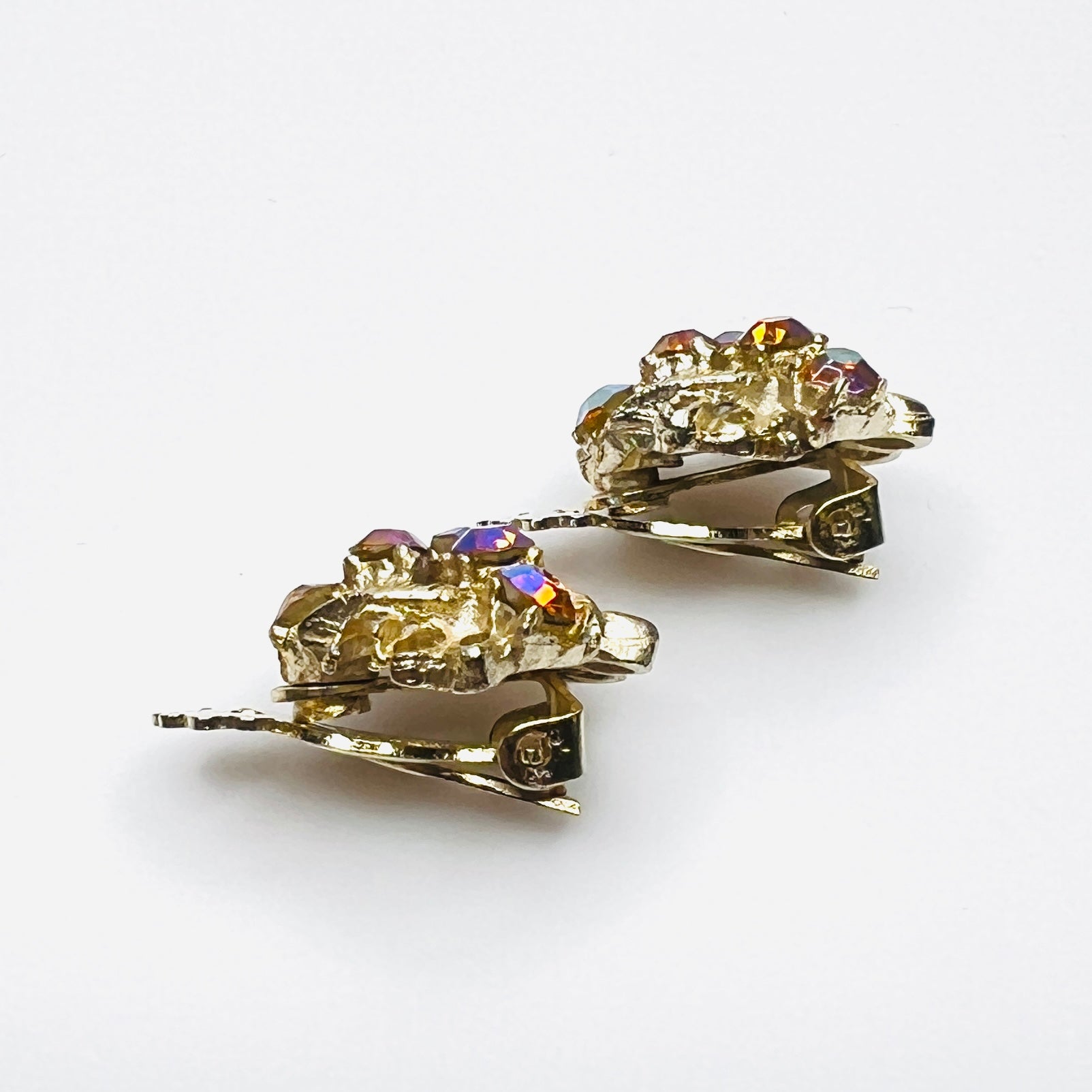 Side profile of vintage gold-tone amber rhinestone clip-on earrings.
