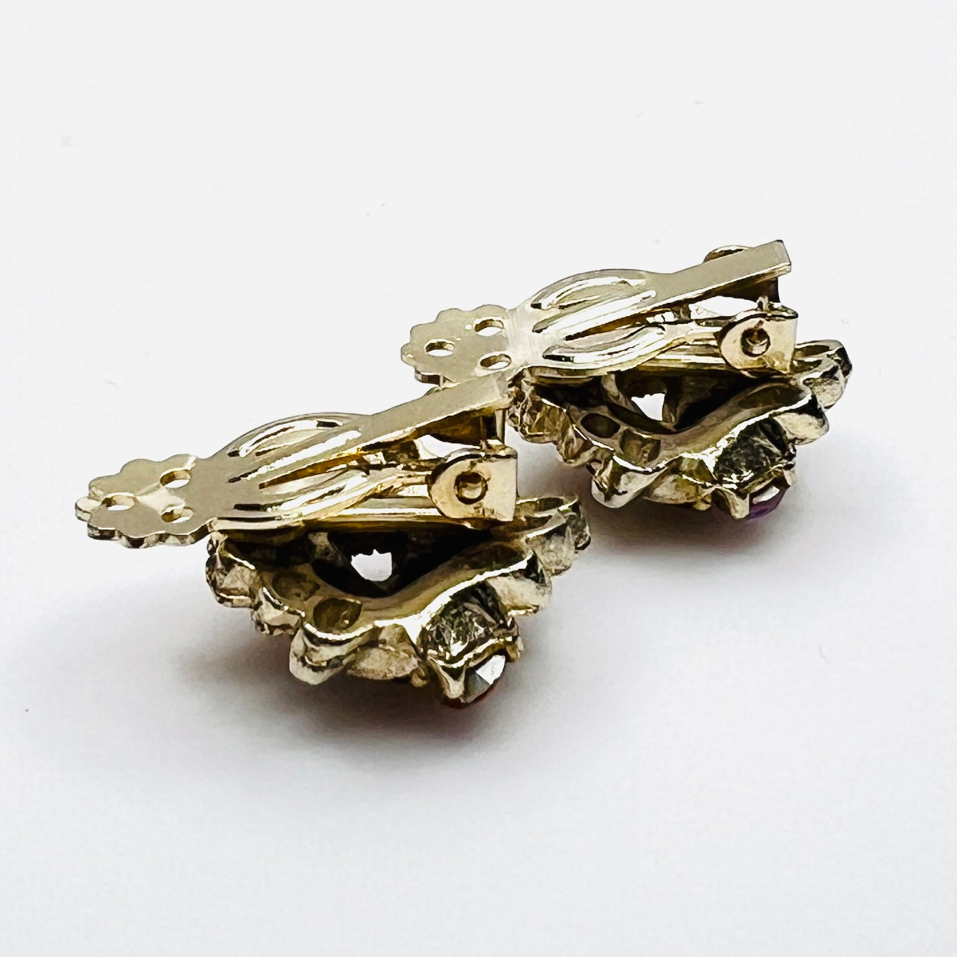 Side profile of vintage gold-tone amber rhinestone clip-on earrings.