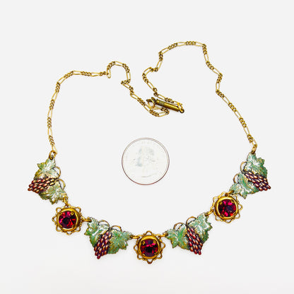 Artisan vintage grape motif necklace with enamel panels shown beside quarter for scale.