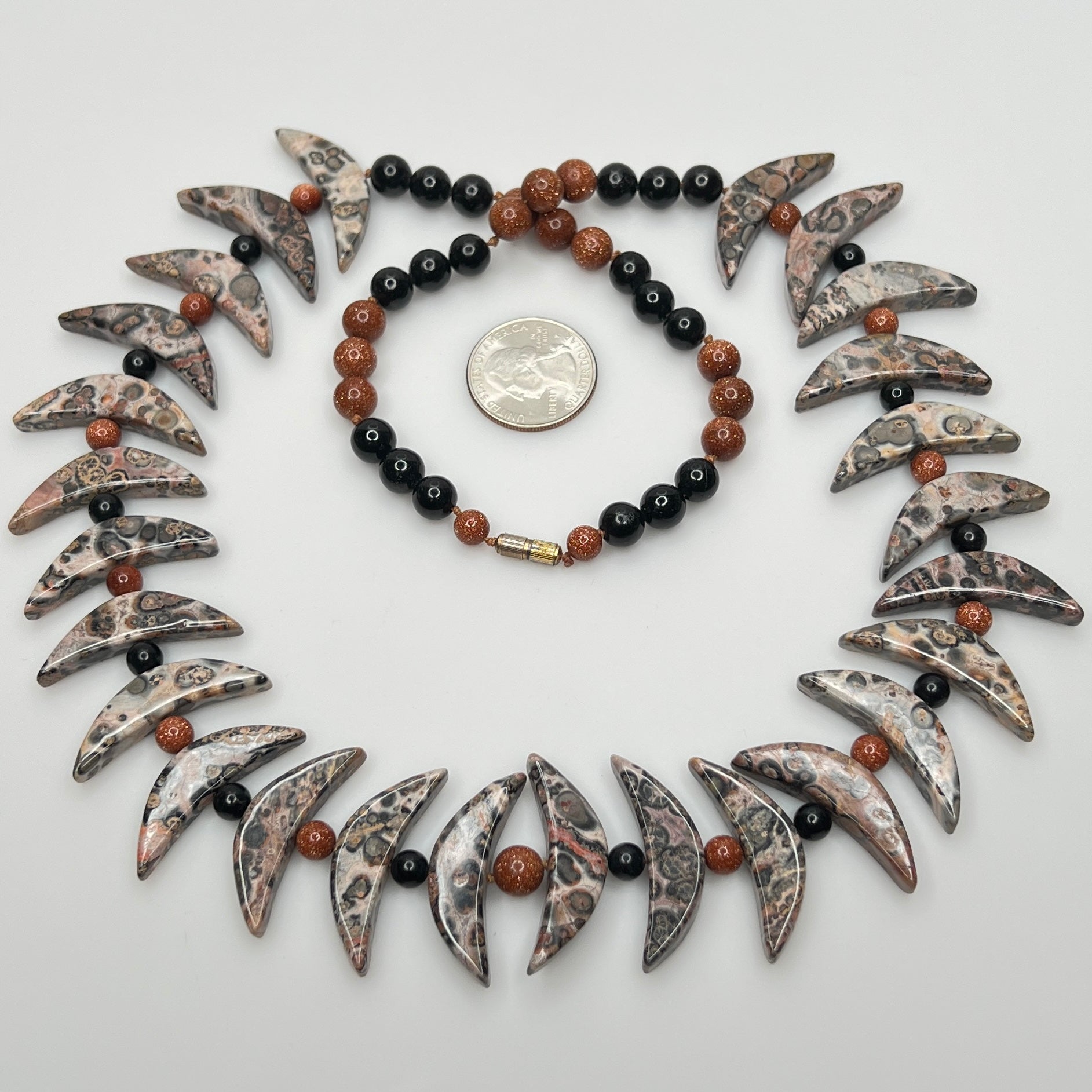 Close-up of asteroid jasper necklace with goldstone and obsidian beads