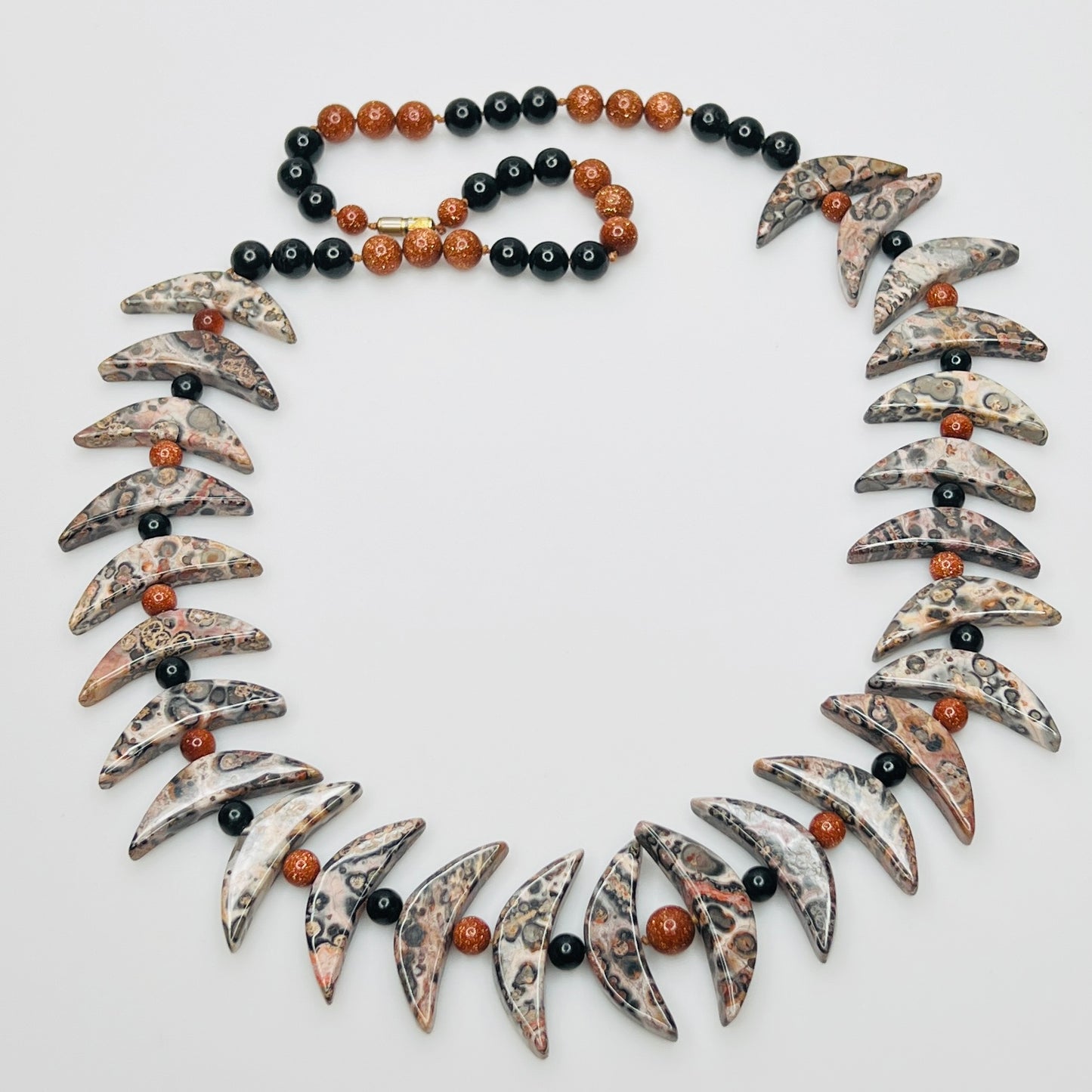 Close-up of asteroid jasper necklace with goldstone and obsidian beads