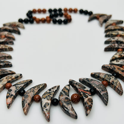 Close-up of asteroid jasper necklace with goldstone and obsidian beads