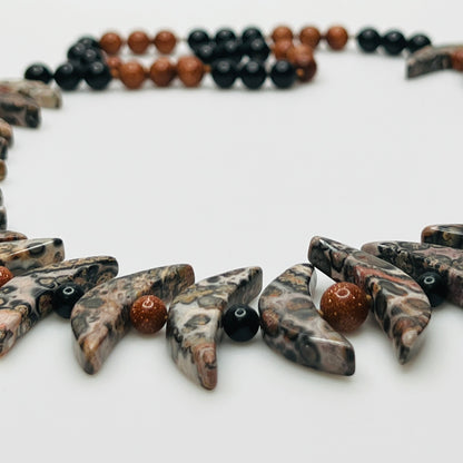Close-up of asteroid jasper necklace with goldstone and obsidian beads