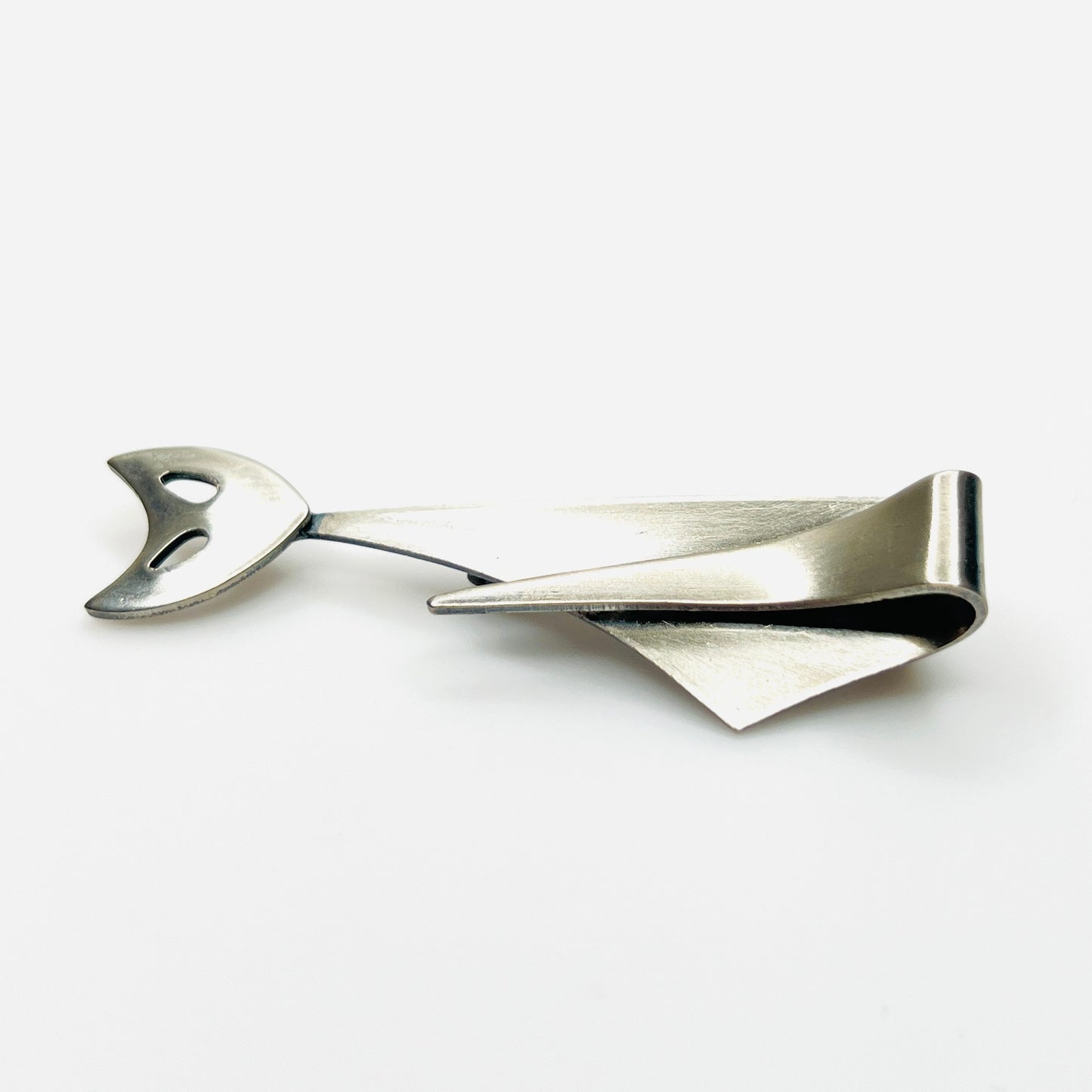 Side profile of vintage Modernist cat brooch showing layered sculptural stainless steel construction.