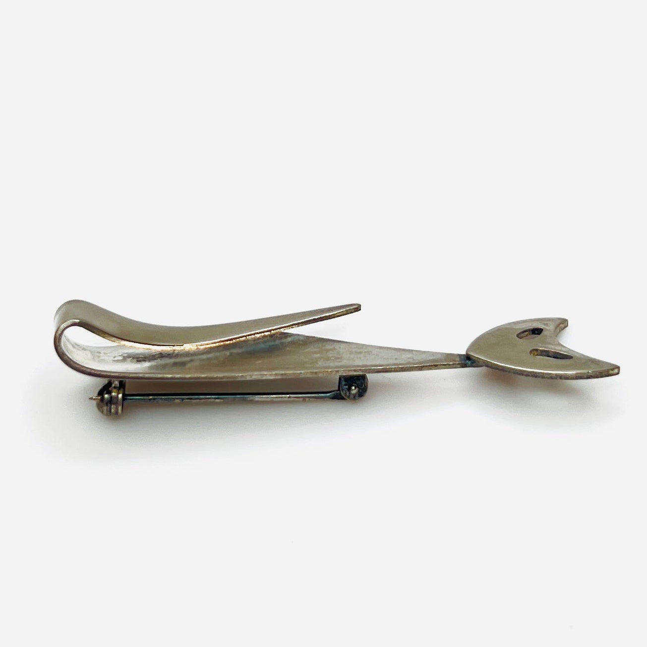 Side profile of vintage Modernist cat brooch showing layered sculptural stainless steel construction.