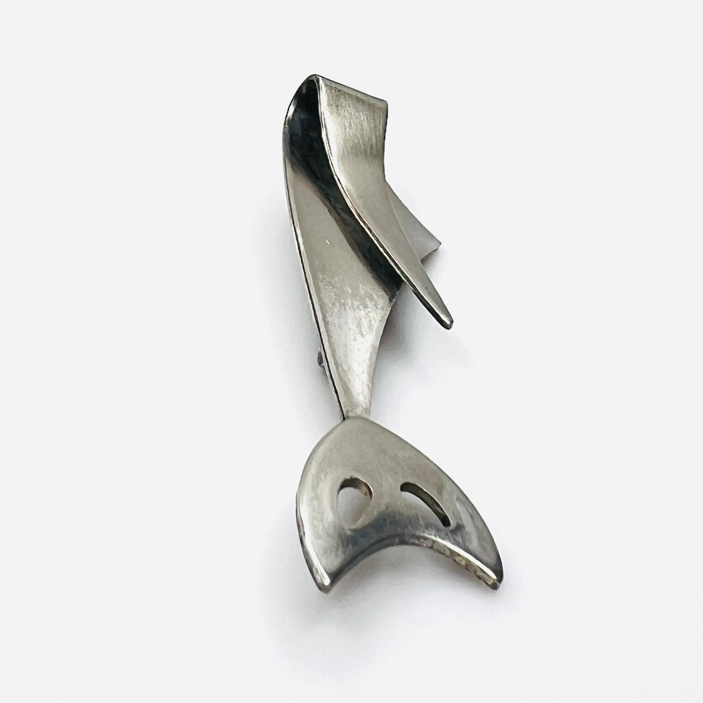 Side profile of vintage Modernist cat brooch showing layered sculptural stainless steel construction.