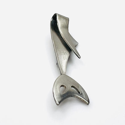 Side profile of vintage Modernist cat brooch showing layered sculptural stainless steel construction.