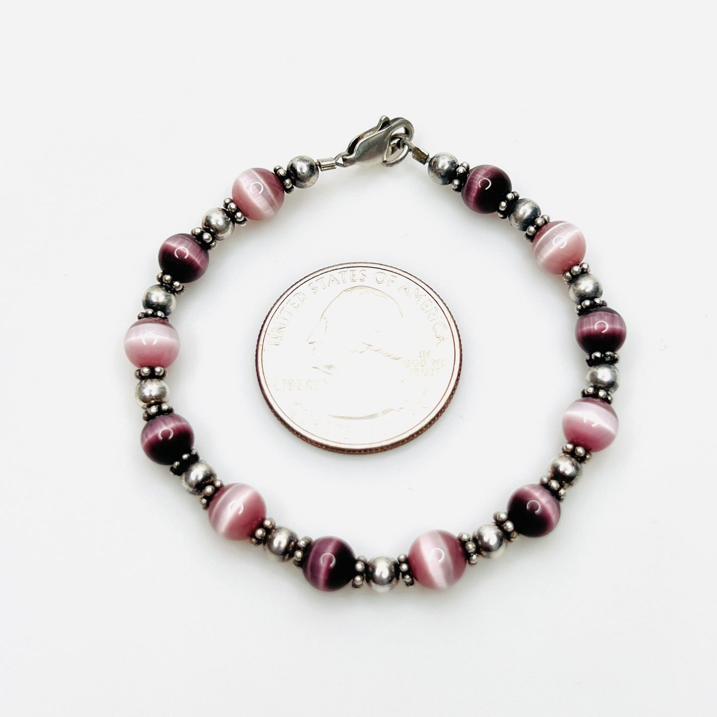 Purple cat's eye sterling silver bracelet shown with quarter for scale