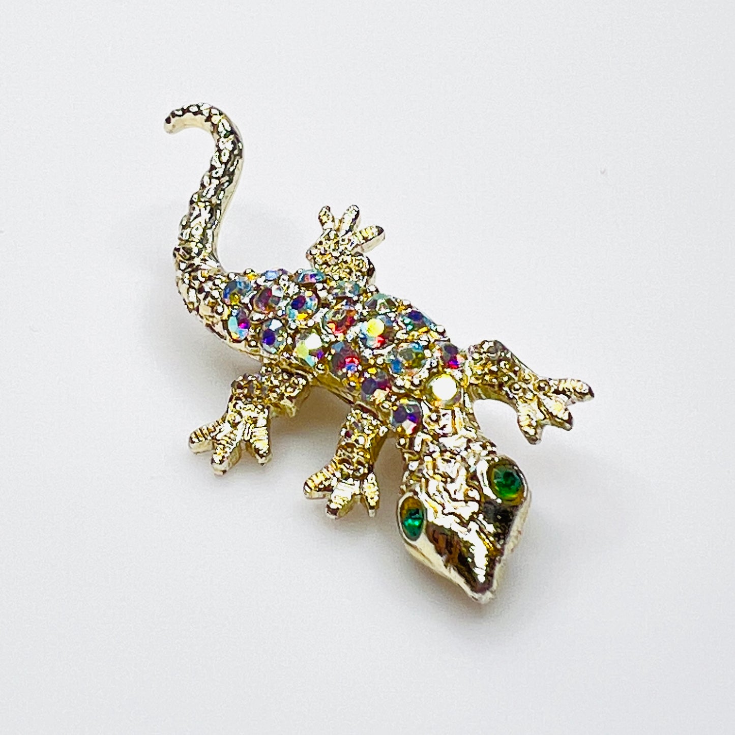 Vintage gold-tone lizard brooch with aurora borealis rhinestones and green crystal eyes.