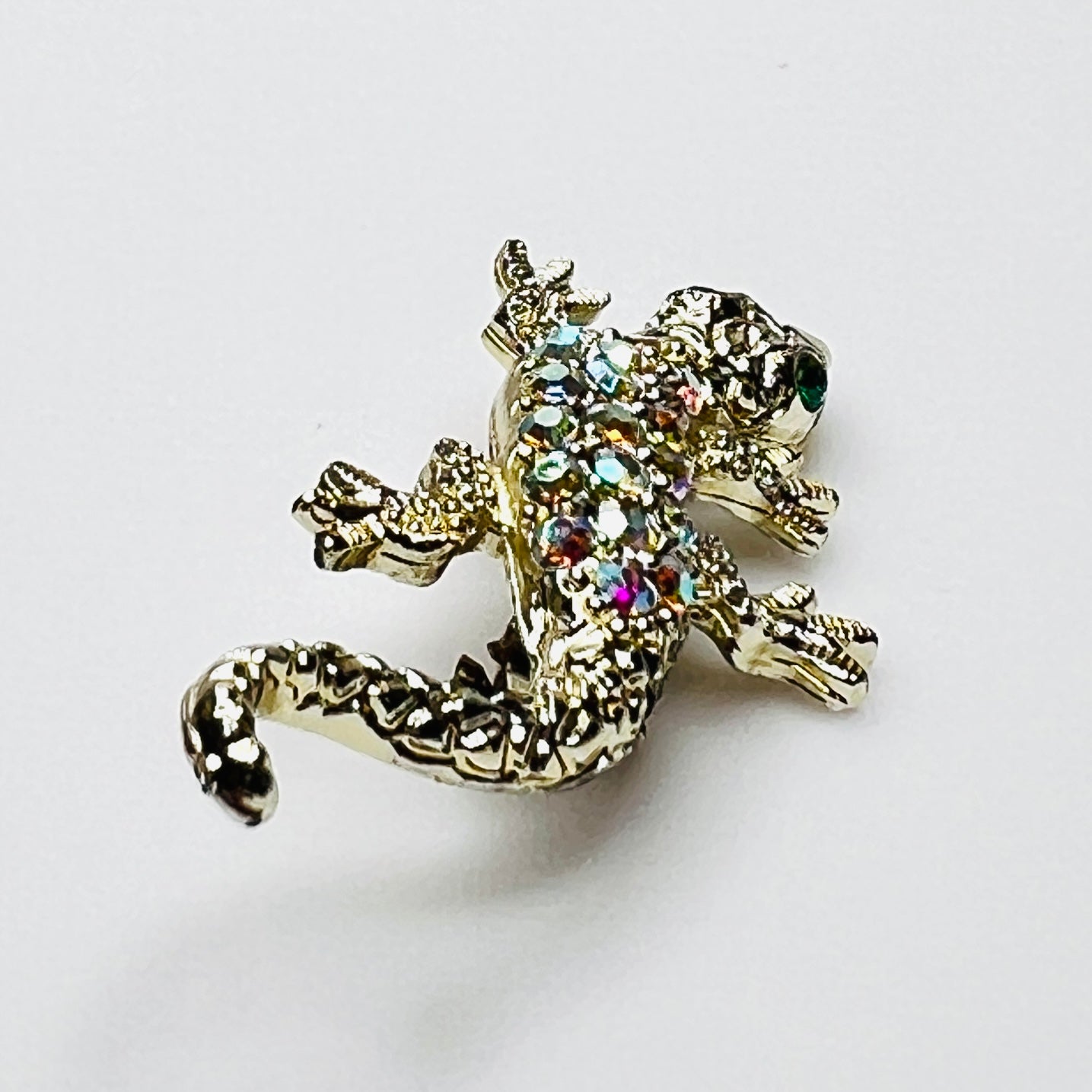 Side profile of vintage rhinestone lizard brooch showing dimensional body and tail.
