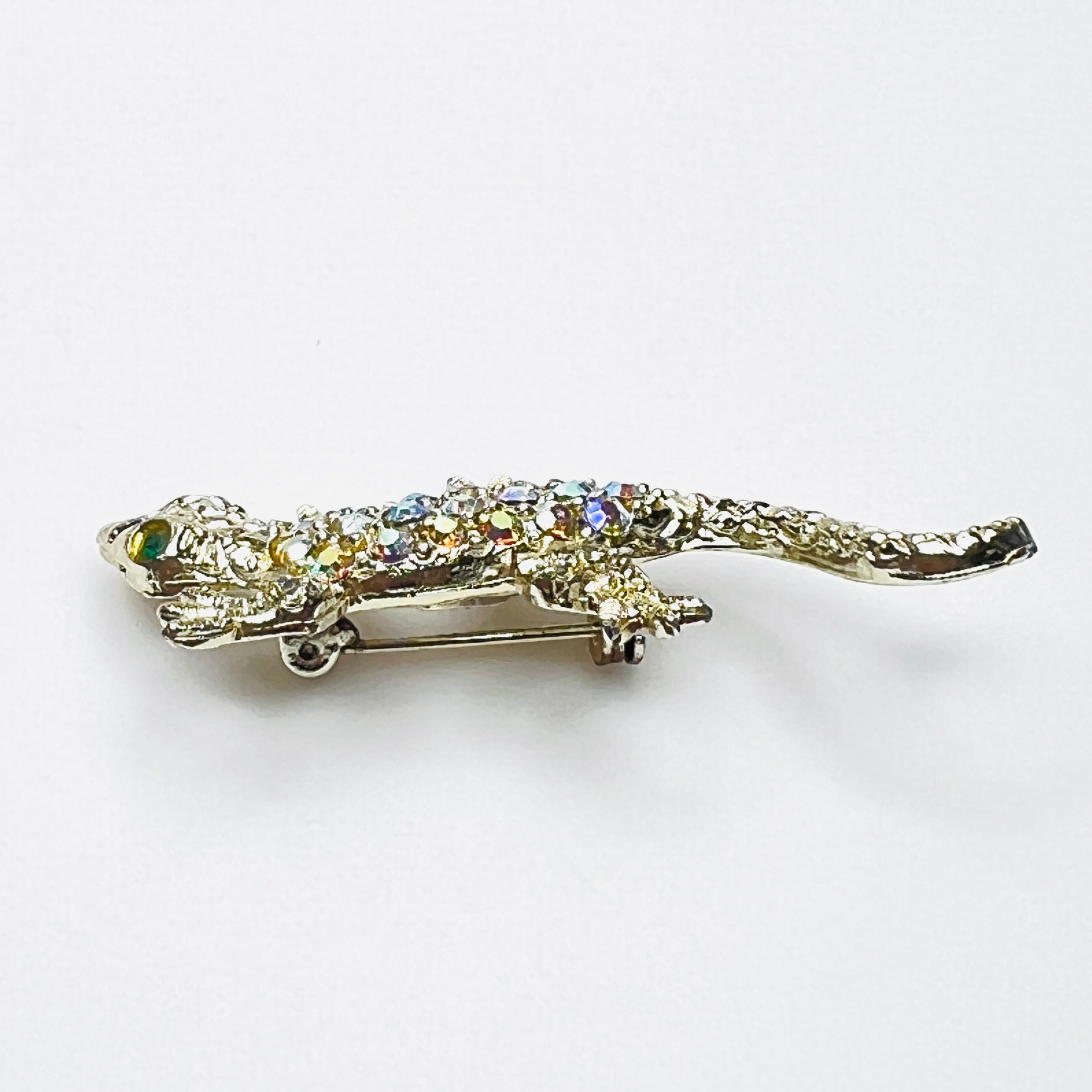 Side profile of vintage rhinestone lizard brooch showing dimensional body and tail.