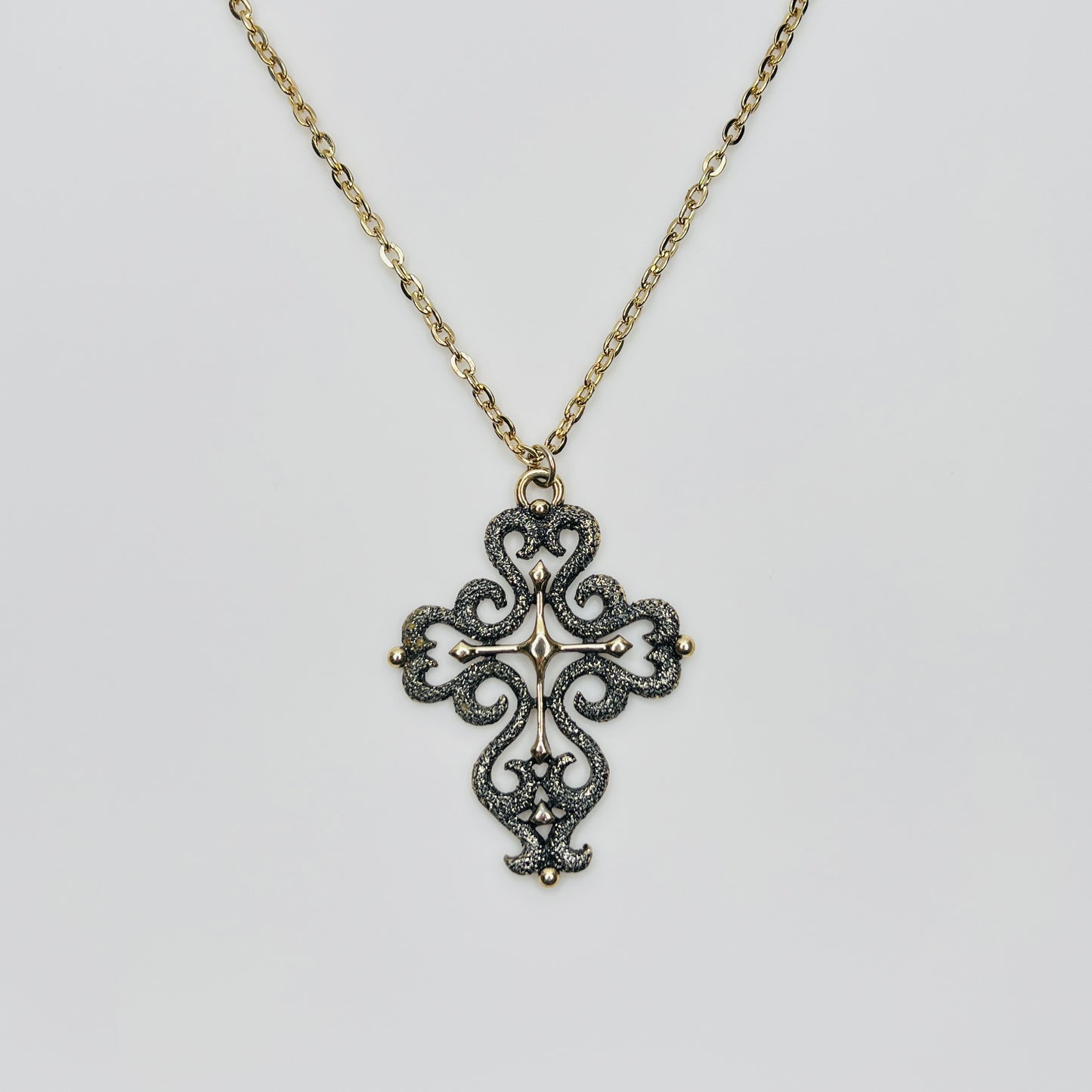 Large gold tone cross pendant necklace with textured filigree design