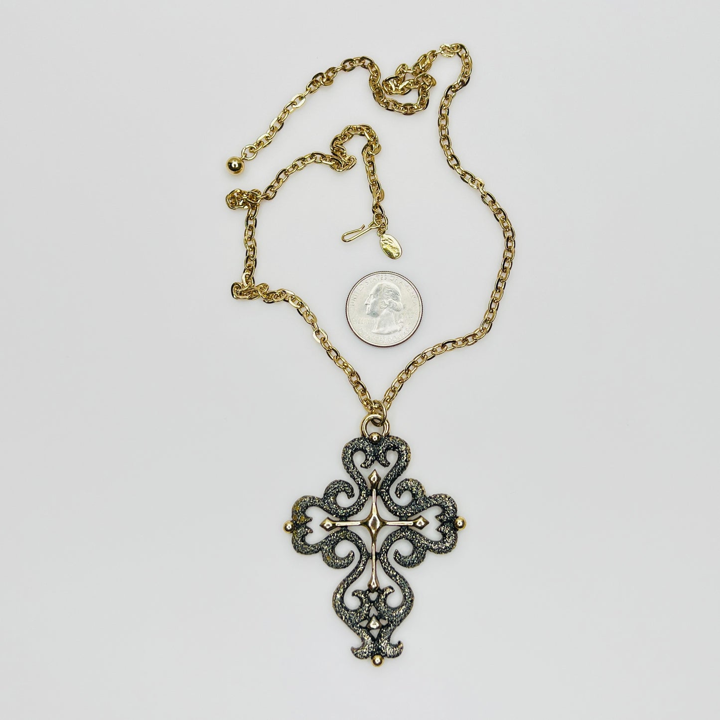 Close-up of ornate cross pendant with dimensional texture