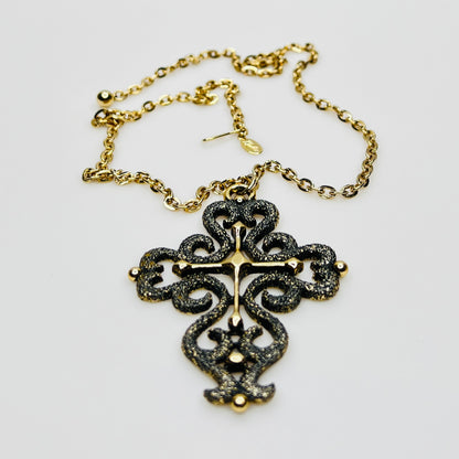 Close-up of ornate cross pendant with dimensional texture