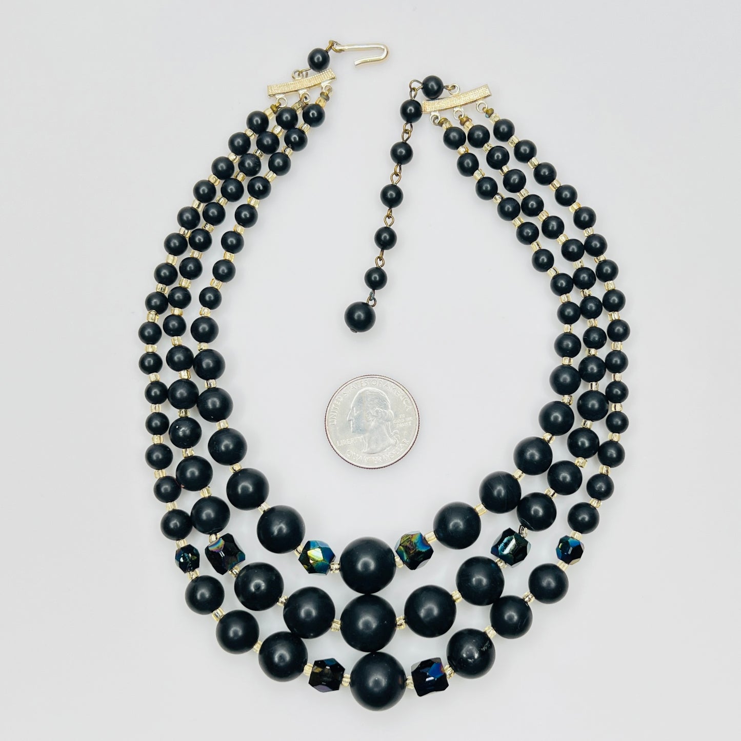 Vintage Japanese black bead necklace beside quarter for scale