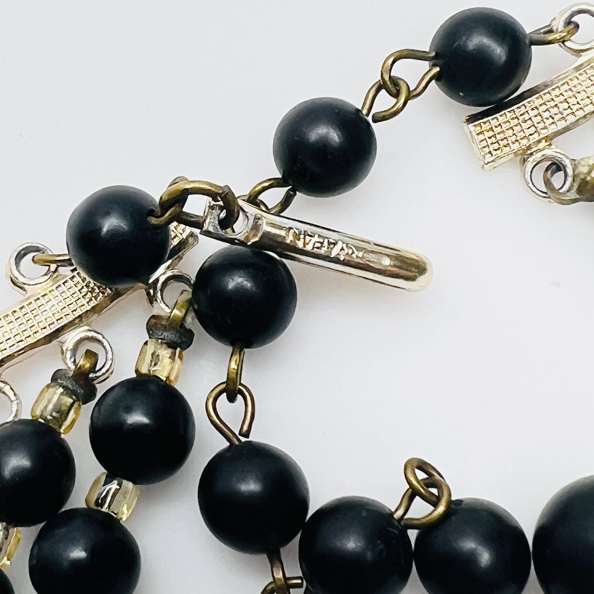 Close view of Japan stamped clasp on vintage black bead necklace