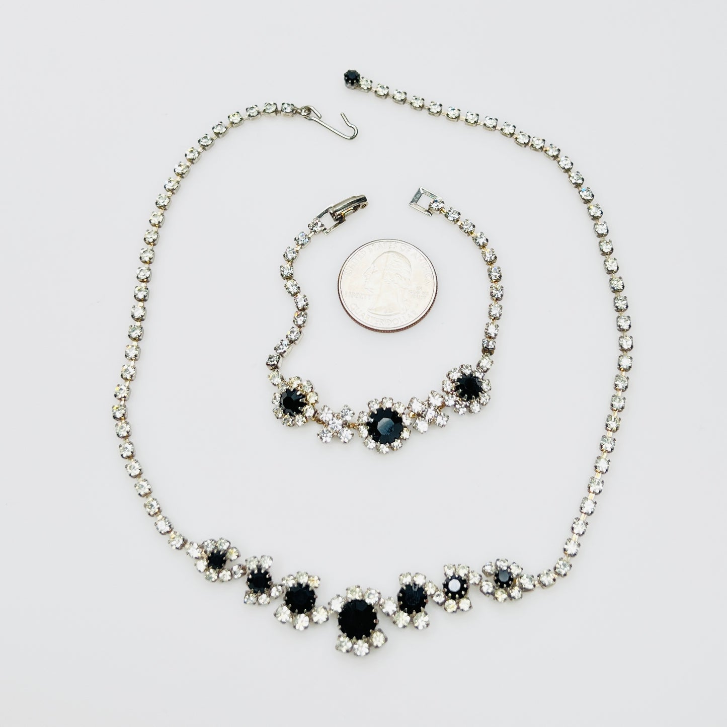 Matching 1950s rhinestone necklace and bracelet beside quarter for scale